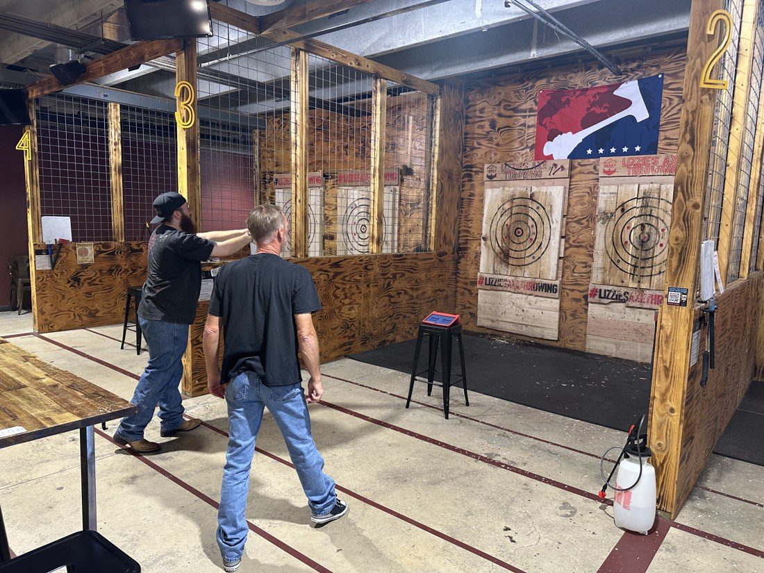 Logan Reid, left, and Dannenberg between throws. The boards are watered before play so the axes bite. Rico Vecchiarelli / AXEOLOGY
